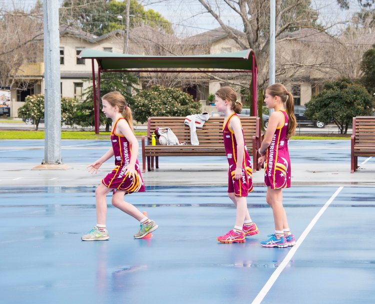 Murrumbeena junior netballers training outdoors in the rain
